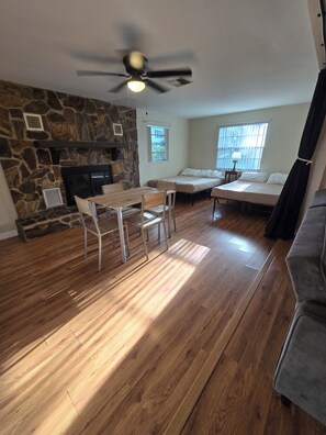 A living room with a stone fireplace, a dining table with chairs, a sofa, and a ceiling fan. - 3-bedroom Chassahowitzka River, by campground, pet friendly
Manatee retreat (Homosassa)