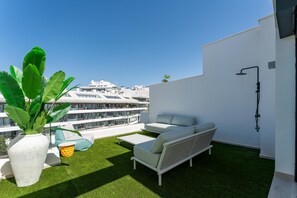 A rooftop terrace with a sofa, a small table, and a potted plant. - 3 Bed Townhouse Escape Costa Del Sol - Pass the Keys (Fuengirola)