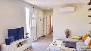 Een moderne woonkamer met een flatscreen televisie, een bank, een salontafel en een kamerkleed met dessin.