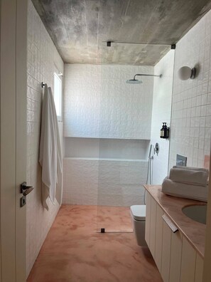 Ein Badezimmer mit Dusche, Toilette und Waschbecken.