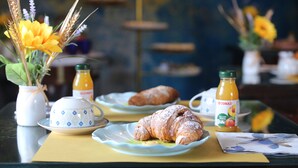 A breakfast setting with a croissant, orange juice, and a cup on a table. - B&B L'Almancco: A Blend of Relaxation and Convenience (Motta Vigana)