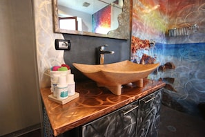 Une salle de bain avec un lavabo en bois, un miroir et un porte-serviettes.