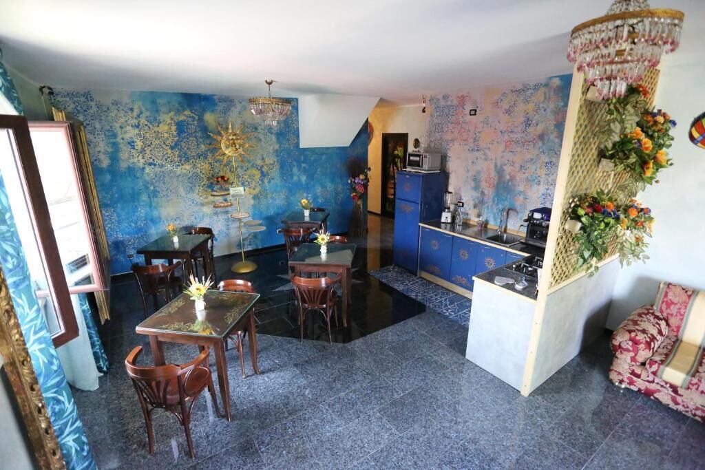 A dining area with a table and chairs, a kitchen area with cabinets, and a decorative wall.
