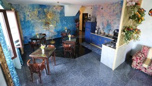 A dining area with a table and chairs, a kitchen area with cabinets, and a decorative wall.