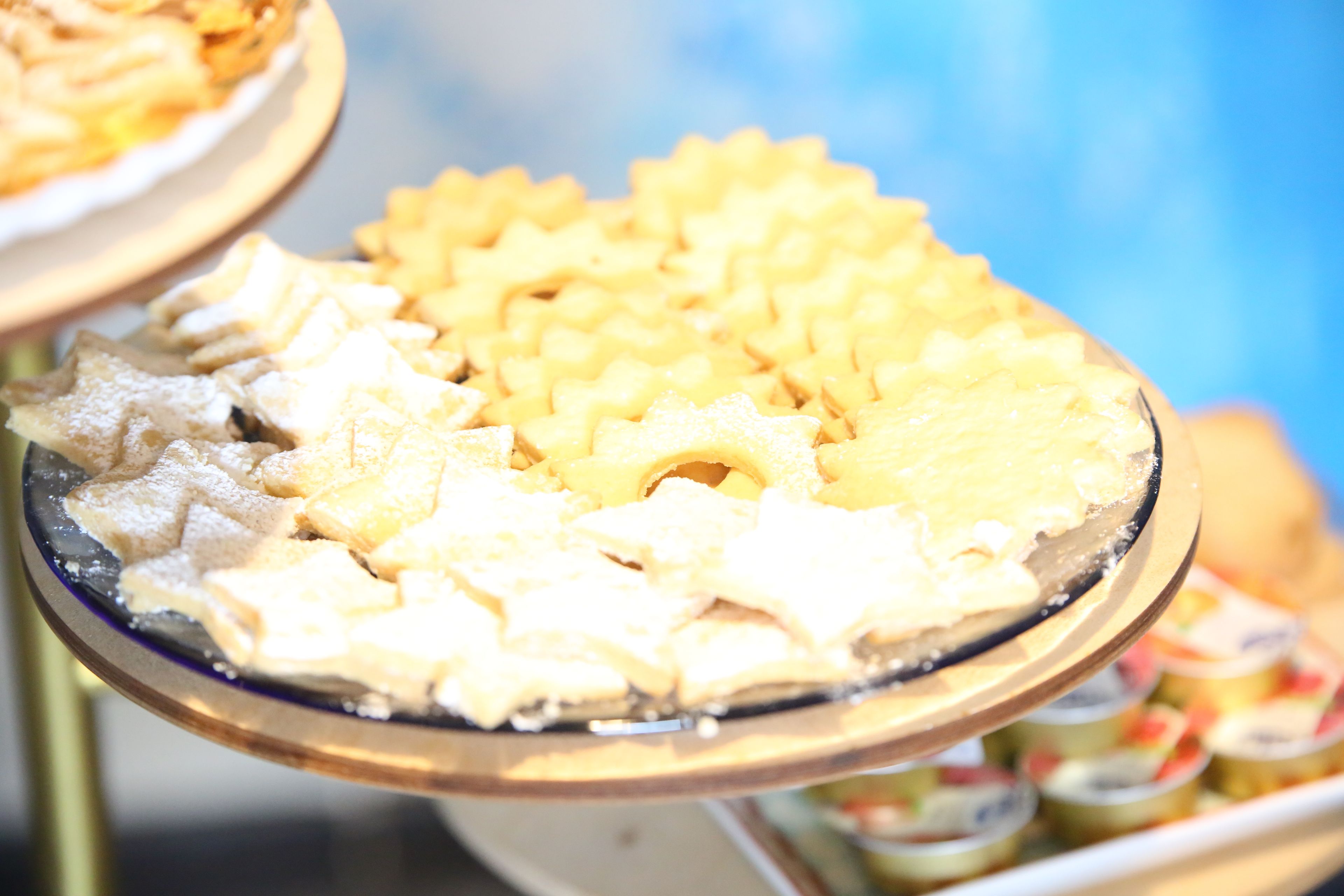 Ein Buffet mit verschiedenen Gerichten, darunter sternförmige Speisen und rechteckige Stücke, vermutlich Desserts oder Vorspeisen.