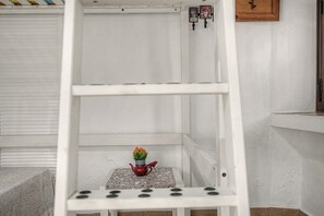A white metal shelf unit with a small table and a red teapot on it. - Historic Center Studio – Terrace and Beach Nearby (Conil de la Frontera)