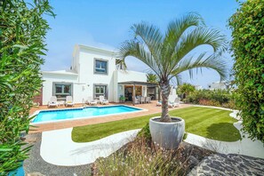 A modern house with a swimming pool, outdoor seating, and a well-maintained garden. - Villa Aguamarina - Three Bedroom Villa, Sleeps 6 (Playa Blanca)