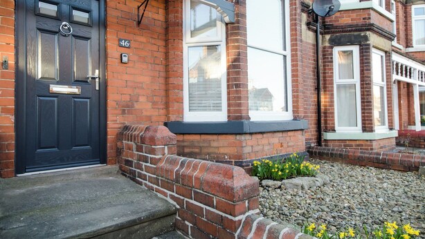 A residential building with a black front door, a brick facade, and a white window frame. - 46 Ashville Avenue (Scarborough)