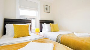 A hotel room with two beds, a window with blinds, a lamp, and a framed picture on the wall. - 46 Ashville Avenue (Scarborough)