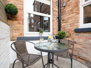 A small outdoor seating area with wicker chairs and a glass table, a potted plant, and a glass pitcher on the table. - 46 Ashville Avenue (Scarborough)