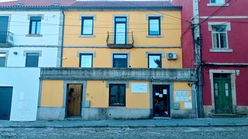 Un edificio de varios pisos con ventanas numeradas y una entrada visible.