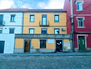 Un edificio de varios pisos con ventanas numeradas y una entrada visible.