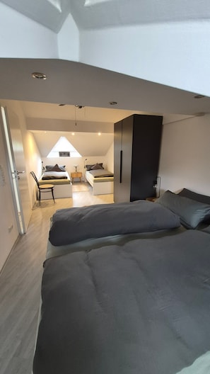 A modern bedroom with a bed, a desk, and a chair.