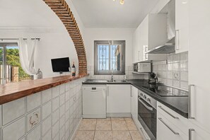 Une cuisine moderne avec des armoires blanches, un comptoir noir et un lave-vaisselle encastré.