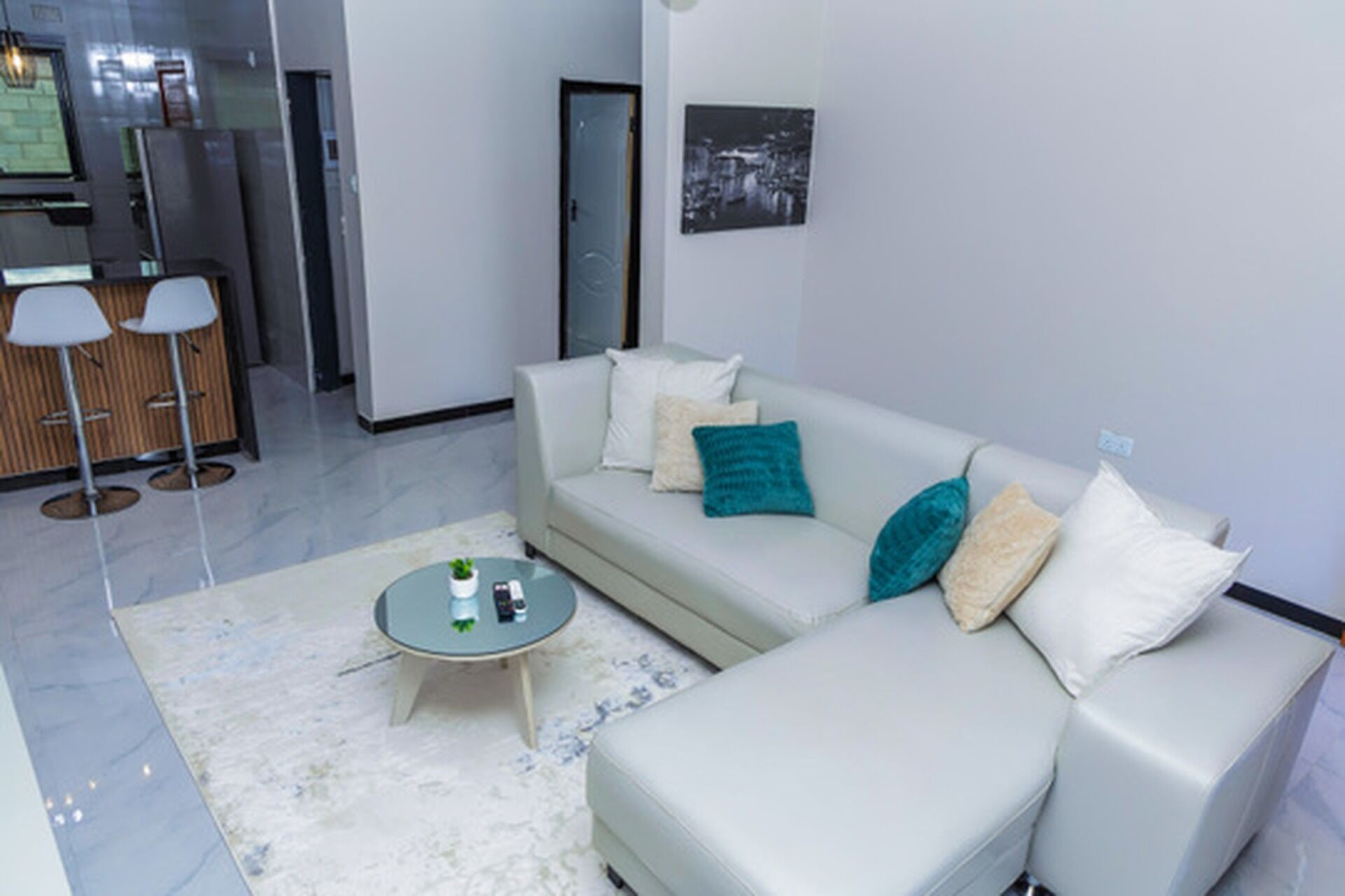 Una sala de estar moderna con un sofá, una mesa de centro y una mesita auxiliar.