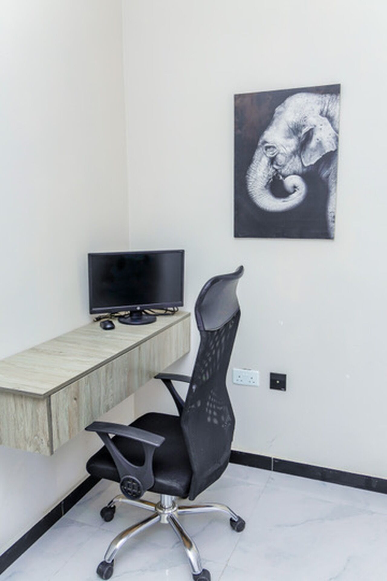 A workspace with a desk, computer, and ergonomic chair.