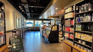 A coffee shop interior with seating, a display case, and a signboard. - Beach Daze. Ocean view studio. (Myrtle Beach)