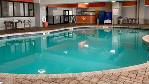 An indoor swimming pool with a tiled edge, a towel rack, and a lifebuoy. - Beach Daze. Ocean view studio. (Myrtle Beach)