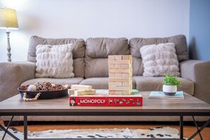 A living room with a coffee table, a Monopoly board game, and a stack of wooden blocks. - Beary Cozy Condo, Hot Tub & Game Room, Dollywood (Sevierville)