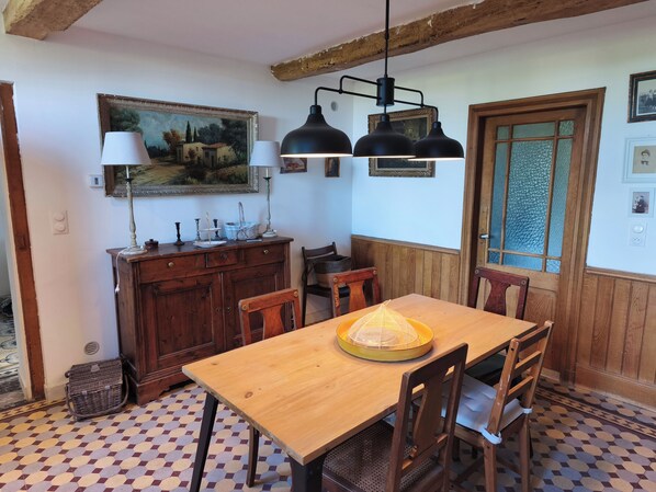 A dining area with a wooden table, chairs, a chandelier, and a painting on the wall. - The Vineyard Horizon - Gaillac Countryside (Gaillac)