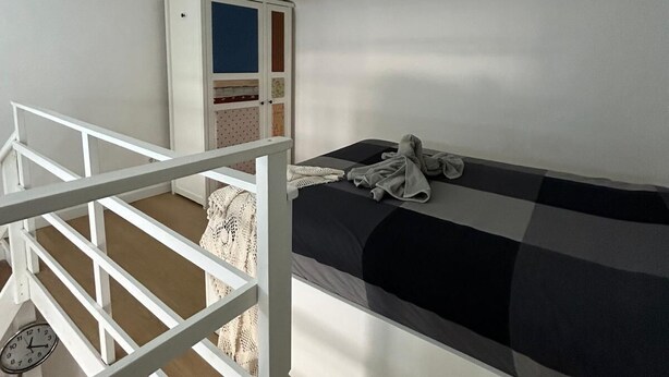 A bedroom with a bunk bed, a white wardrobe, and a clock on the wall. - Bari Love Loft - Historic Center, Beach, Train Station, and Airport Just a Short Walk Away (Bari)