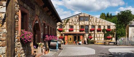 A traditional half-timbered building with flower boxes and a cobblestone courtyard.