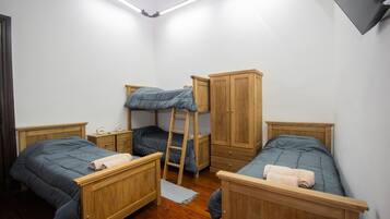 Un dormitorio tipo residencia con literas, armarios de madera y una escalera.