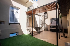 A courtyard with a spiral staircase, a small outdoor seating area, and a green artificial turf. - A guesthouse with an excellent location, a gym, and a game room (Buenos Aires)