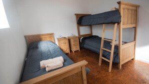 A room with a bunk bed, a single bed, wooden furniture, and a small bedside table. - A guesthouse with an excellent location, a gym, and a game room (Buenos Aires)