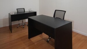 A room with a large black desk, a smaller desk, a chair, and a ceiling-mounted air conditioning unit. - A guesthouse with an excellent location, a gym, and a game room (Buenos Aires)