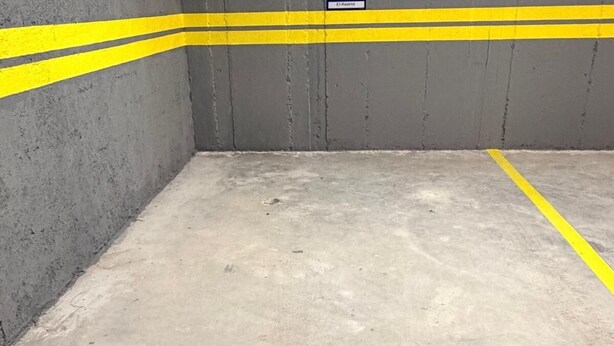 A parking garage with concrete walls and yellow lines marking the parking spaces. - Sea View & Pool, Elite Resort (Saranda)