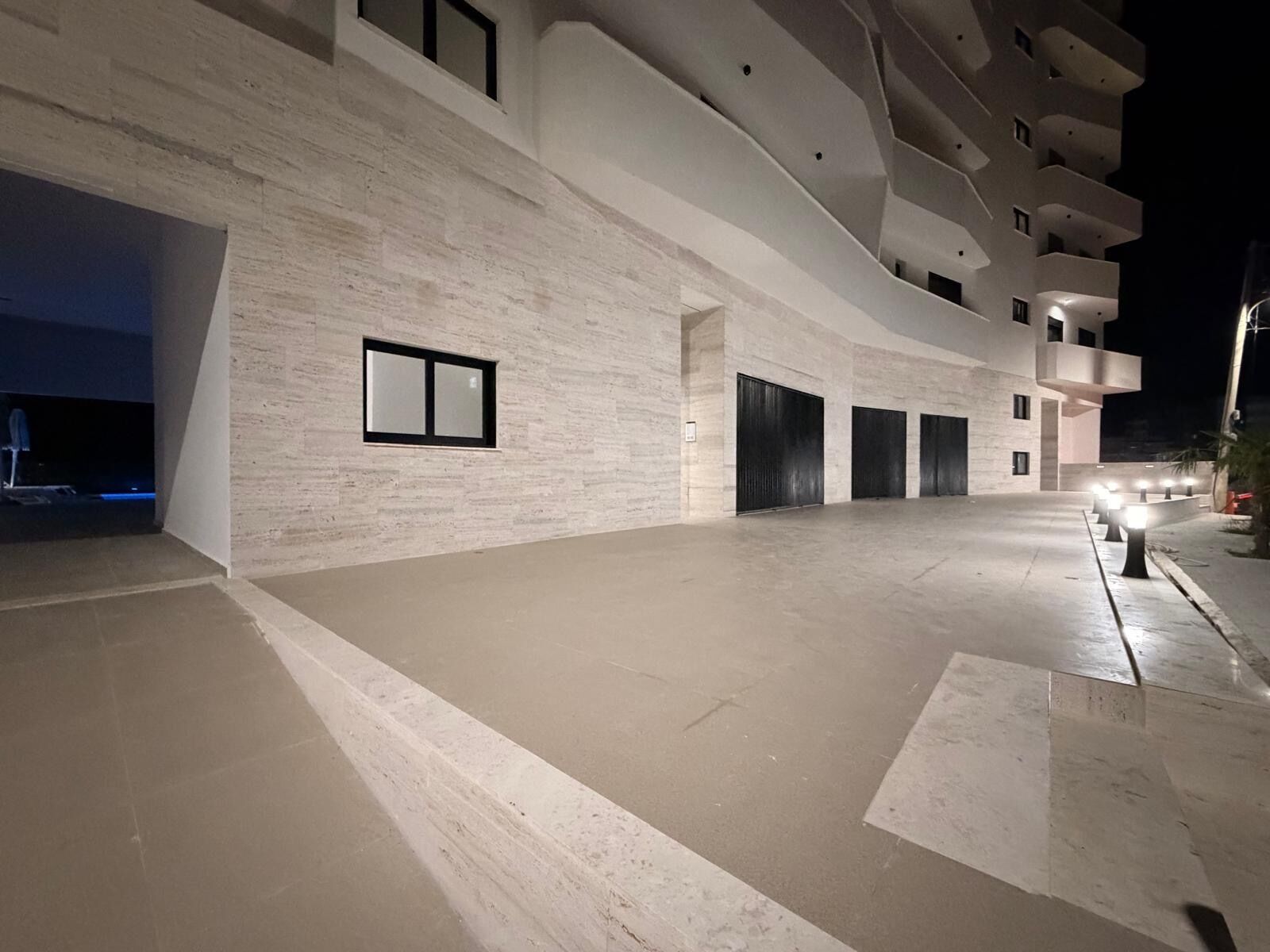 A modern building with a flat facade, large windows, and a spacious entrance area.