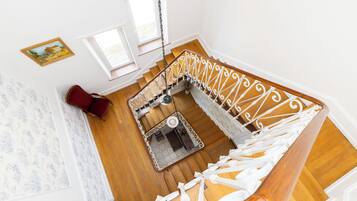 A staircase with white balustrades and wooden steps, leading to an upper floor.