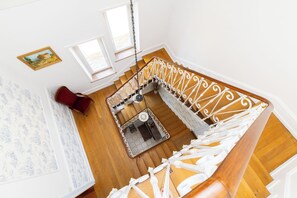 A staircase with white balustrades and wooden steps, leading to an upper floor. - Le Domaine d'Amélie: An Elegant Vacation Rental on the Outskirts of Nancy (Dombasle-sur-Meurthe)