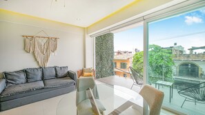 A modern living room with a grey sofa, a glass coffee table, and a view of the city through large windows. - Torre Ku, Near the Beach & Rooftop Pool (Puerto Vallarta)