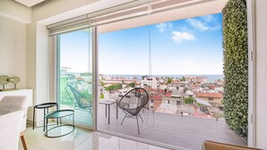 A balcony with a city view, a chair, and a table. - Torre Ku, Ocean Views Near the Beach (Puerto Vallarta)