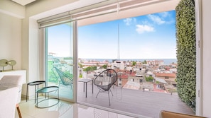 Ein Balkon mit Blick auf die Stadt, ein Stuhl und ein Tisch.