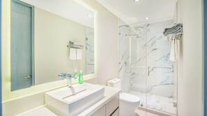Een moderne badkamer met een grote spiegel, een wastafel, een toilet en een douchecabine met glazen wanden.