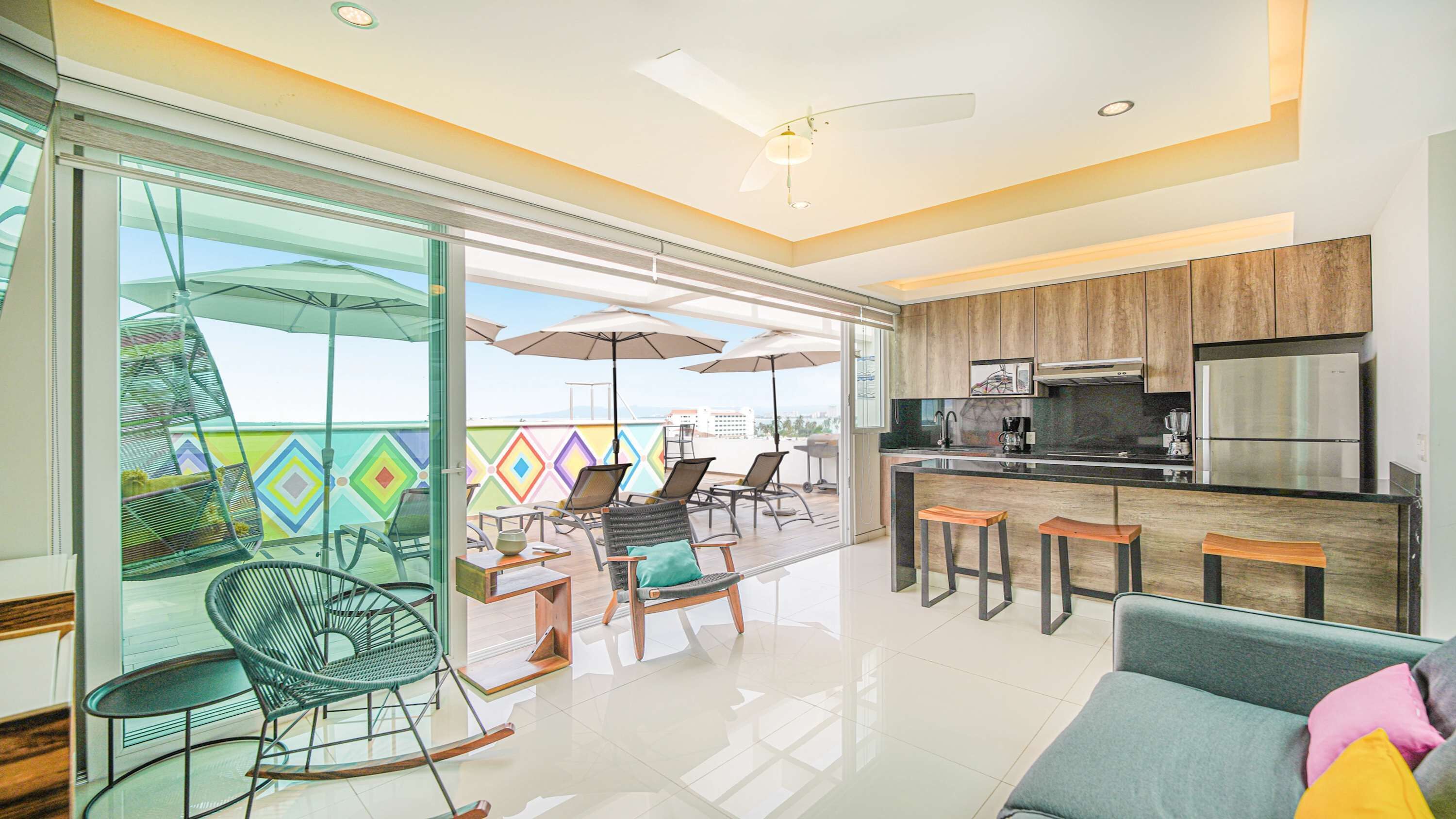 A modern kitchen with a stainless steel refrigerator and a dining area with a glass partition.