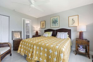 Ein Schlafzimmer mit einem Bett, zwei Nachttischen, einem Sessel und Bildern an den Wänden.