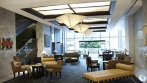 A hotel lobby with a seating area, a staircase, and a large window. - Eurobuilding Hotel and Suites Caracas (Caracas)