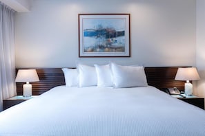 A hotel room with a large bed, two bedside tables with lamps, a framed artwork on the wall, and a window with curtains. - Eurobuilding Hotel and Suites Caracas (Caracas)