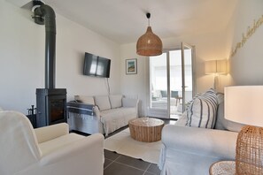 Ein modernes Wohnzimmer mit Kamin, Fernseher und Sofa.