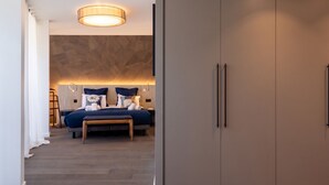 A modern bedroom with a large wardrobe, a bed with multiple pillows, and a bedside table. - Penthouse Annecy74 - Vue panoramique sur le lac (Annecy)