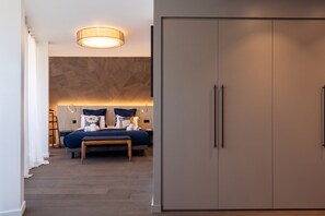 A modern bedroom with a large wardrobe, a bed with multiple pillows, and a bedside table. - Penthouse Annecy74 - Vue panoramique sur le lac (Annecy)
