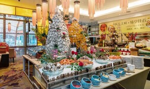 Zona de bufé con diversos alimentos y elementos decorativos.