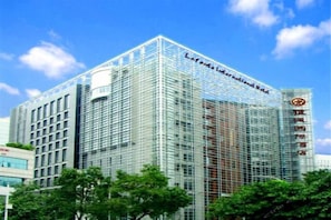 Un edificio moderno con fachada de vidrio, un cartel que dice 'Lafont International Hotel' y un logotipo en el lado derecho.