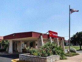 Un edificio con techo rojo y un letrero que dice 'Econo Lodge'.