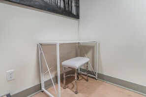 A room with a white metal desk and bench, a painting on the wall, and a light switch on the wall. - Industrial Loft  - Nearby Parking Downtown - 2F (Louisville)