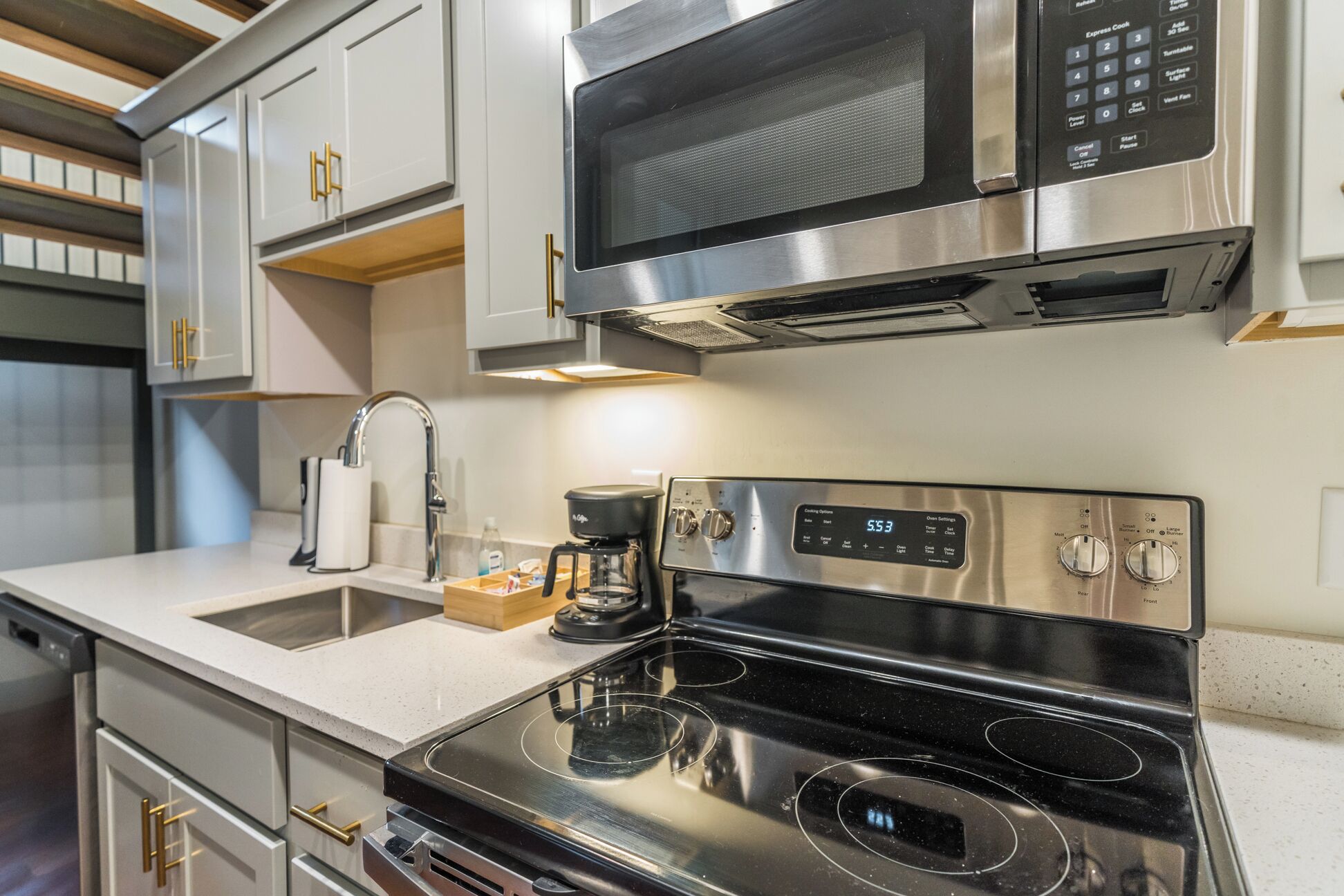 A modern kitchen with stainless steel appliances, including a microwave, oven, and stovetop.